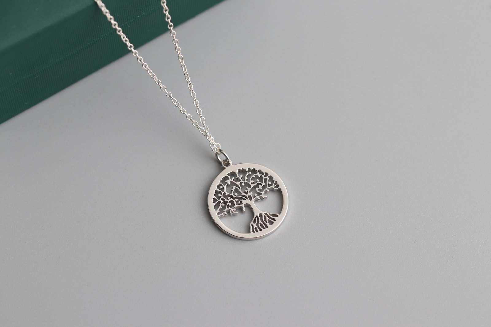 ¿Cuál es el significado del árbol de la vida en acero?, a silver tree of life pendant on a chain